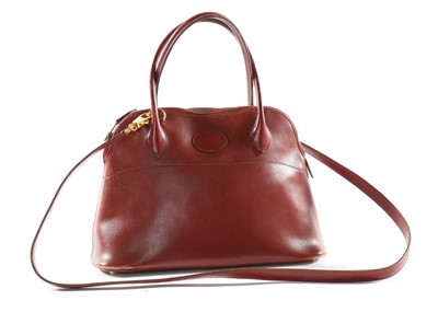 Lot 299 - A small Hermès Bolide burgundy leather handbag,...