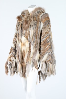 Lot 132 - A knitted fur poncho with hood and toggle...