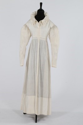 Lot 409 - A white cotton dress, late 1820s, the hem with...