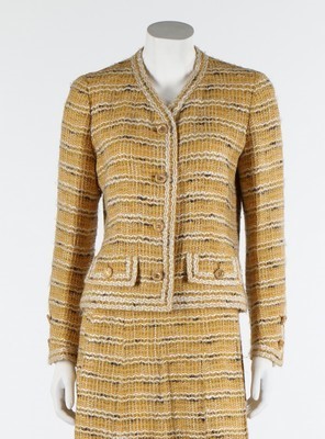 Lot 35 - A Chanel couture yellow tweed suit, late 1960s-...