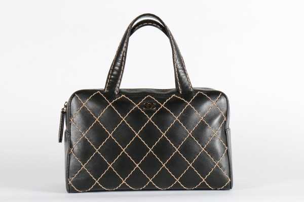 Lot 24 - A Chanel black leather tote bag, label to...