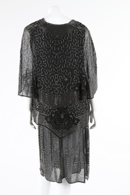 Lot 112 - A beaded black crepe flapper dress and similar...