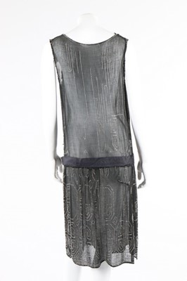 Lot 112 - A beaded black crepe flapper dress and similar...