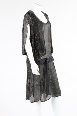 Lot 112 - A beaded black crepe flapper dress and similar...