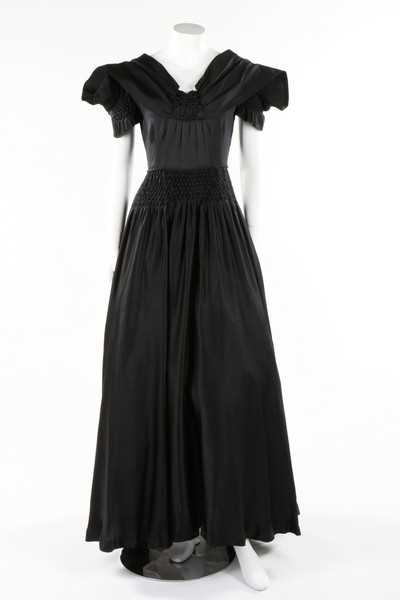 Lot 50 - A Norman Hartnell couture black satin dress,...