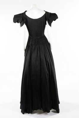 Lot 50 - A Norman Hartnell couture black satin dress,...