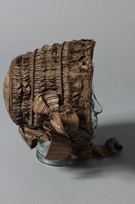 Lot 100 - A brown taffeta bonnet, circa 1850, with...