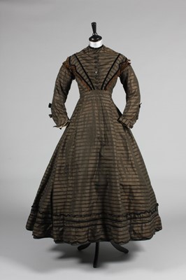 Lot 128 - A striped brown silk day dress, circa 1865,...