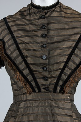 Lot 128 - A striped brown silk day dress, circa 1865,...