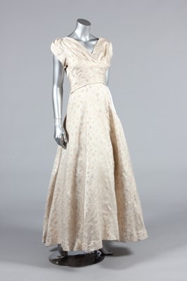 Lot 143 - A gold and ivory brocaded satin bridal gown,...