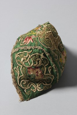 Lot 150 - An embroidered green satin baby cap, probably...