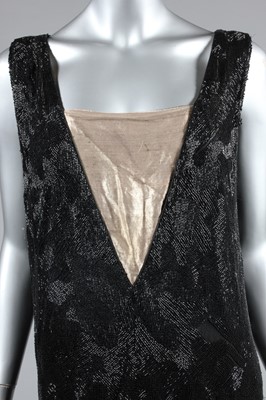 Lot 15 - A black beaded flapper dress, mid 1920s, the...