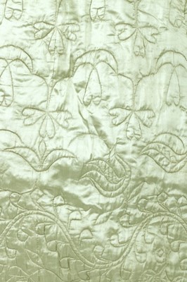 Lot 25 - A quilted pale green satin petticoat, second...